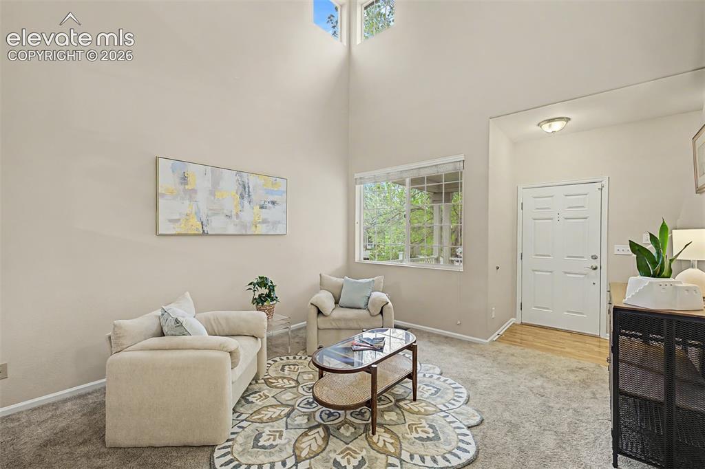 Image 4 of 45: Living area featuriing soaring vaulted ceilings and ample natural light