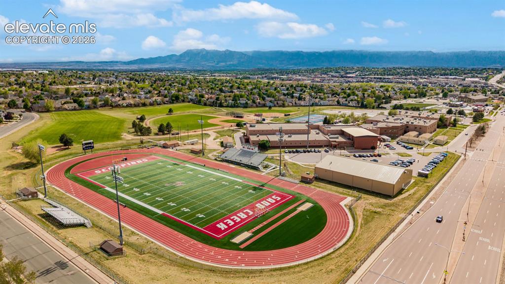 Image 42 of 45: Aerial view of the home on bottom left and Sand Creek High School in the di