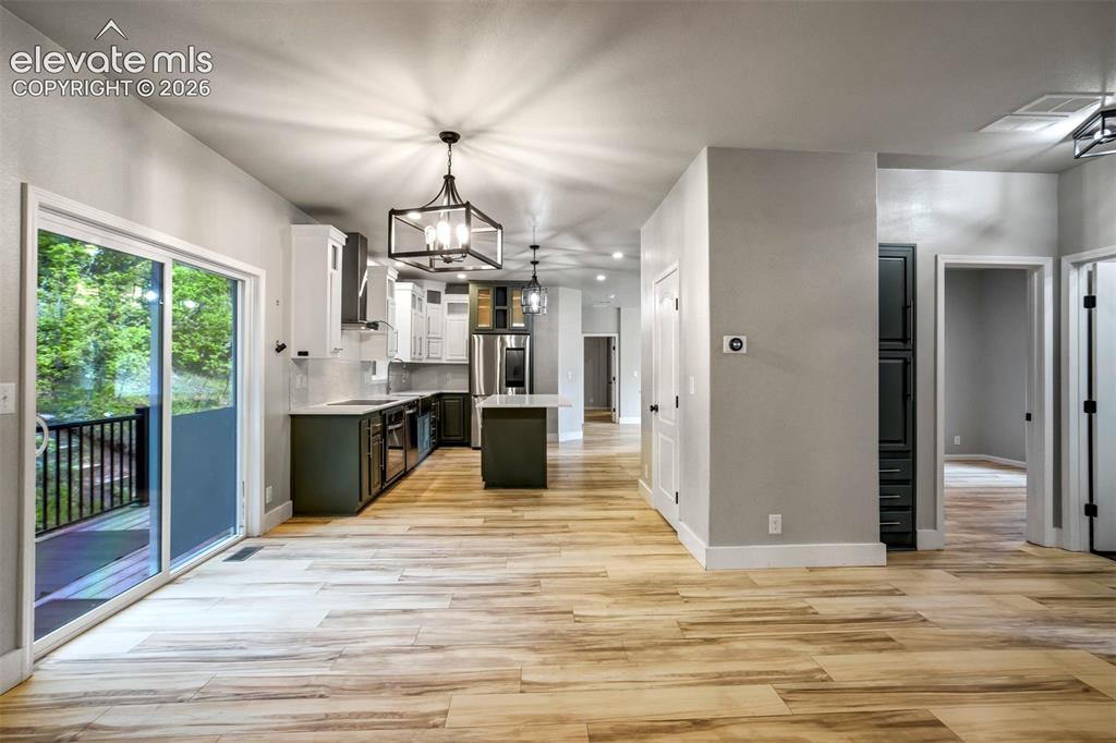 Image 12 of 48: Open-concept living space featuring wood-finish flooring and recessed light