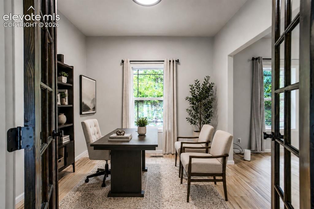 Image 13 of 48: French doors opening to a versatile room with light wood-finish flooring, a