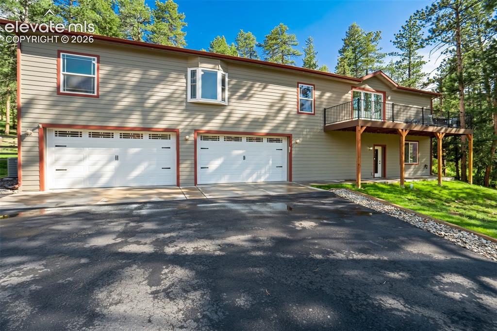 Image 2 of 48: Exterior featuring horizontal siding, two white garage doors with window ac