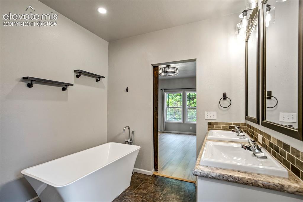 Image 20 of 48: Bathroom featuring a freestanding soaking tub with floor-mounted faucet, du