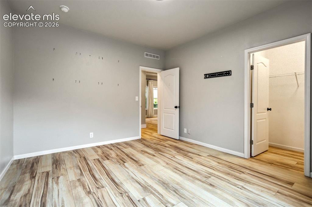 Image 24 of 48:  Bedroom 3 Spacious room featuring wood-finish flooring, light grey walls, 