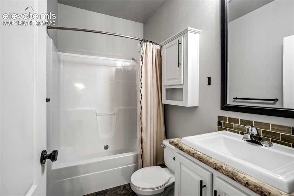 Image 27 of 48: Bathroom featuring a white integrated sink vanity with a patterned countert