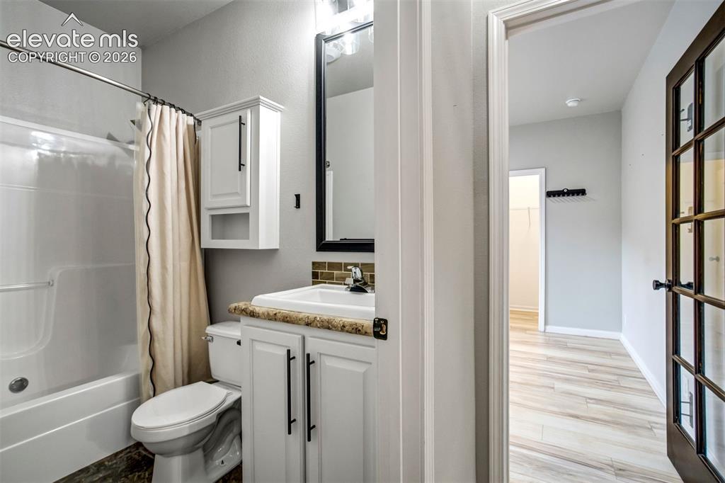 Image 28 of 48: Bathroom featuring a white vanity with cabinet storage, coordinating wall-m
