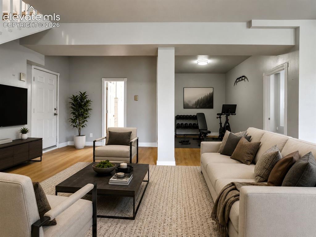 Image 33 of 48: Spacious living area featuring wood-finish flooring, light neutral wall ton