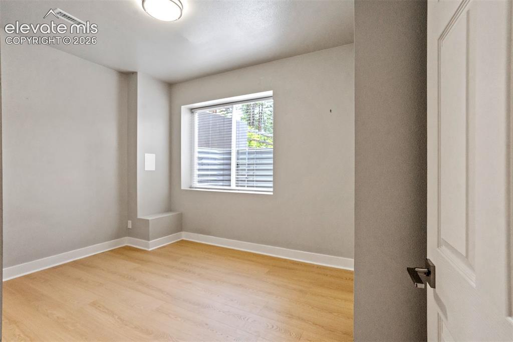 Image 36 of 48: Room featuring wood-finish flooring, white baseboards, a single window with