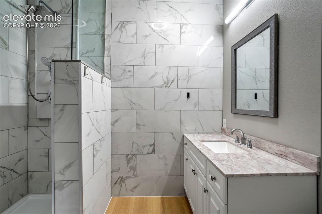 Image 39 of 48: Lower level bathroom with a walk-in shower featuring a rain showerhead and 