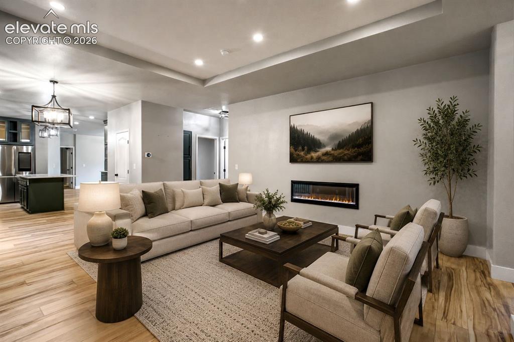 Image 7 of 48: Spacious living area featuring light wood-finish flooring, recessed lightin