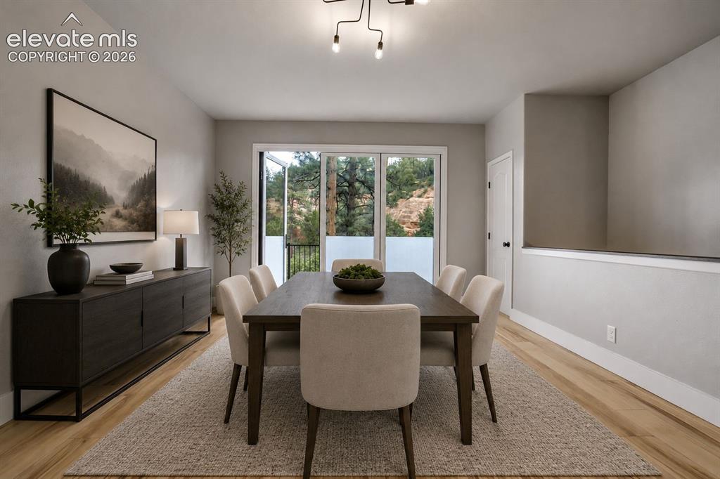 Image 9 of 48: Dining area with wood-finish flooring and a contemporary chandelier