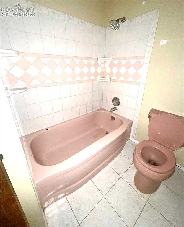 Image 22 of 37: Bathroom Featuring a Pink Bathtub, matching Pink Toilet, and White Wall Til