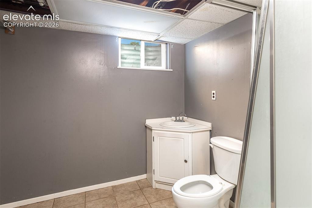 Image 27 of 37: Basement Bathroom. Shower Door is Broken