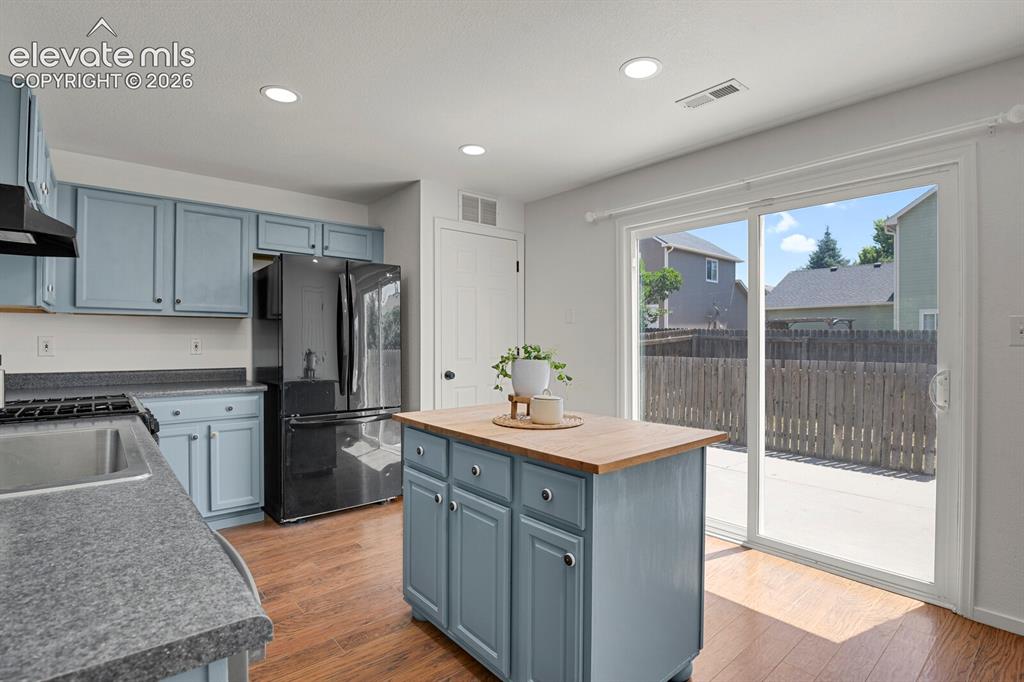 Image 17 of 49: Kitchen featuring wood-finish flooring, recessed lighting, and a center isl