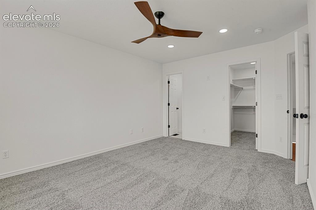 Image 24 of 49: Carpeted room featuring a modern ceiling fan, recessed lighting, and a walk