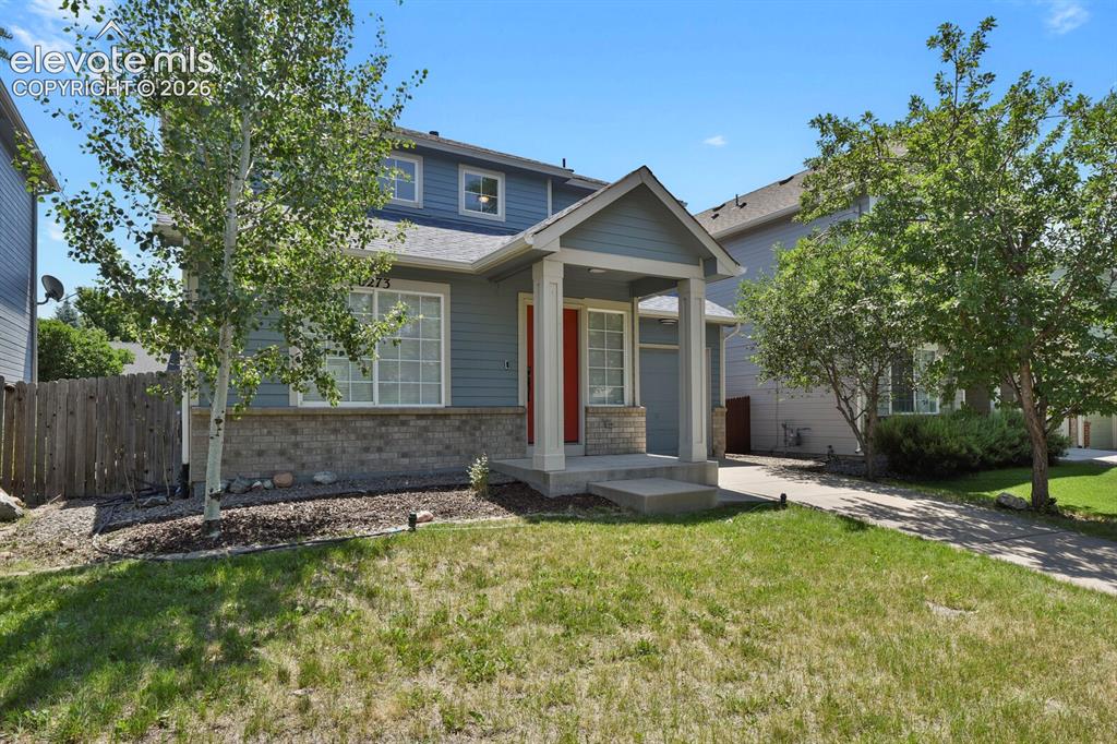 Image 3 of 49: Two-story residence featuring light blue siding, a covered entry porch, and