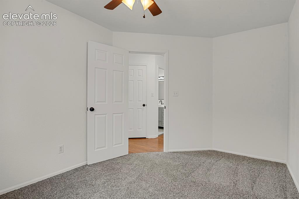 Image 30 of 49: Spacious room featuring gray textured carpeting and white painted walls
