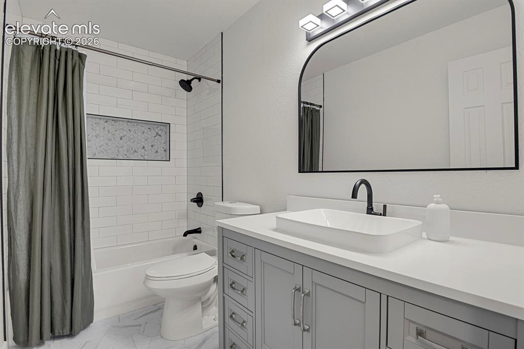 Image 32 of 49: Bathroom featuring a modern vanity with a vessel sink, a full bathtub with