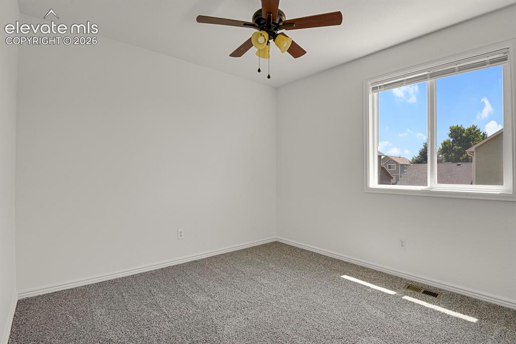 Image 33 of 49: Spacious room featuring neutral carpeting, white walls, and a multi-pane wi