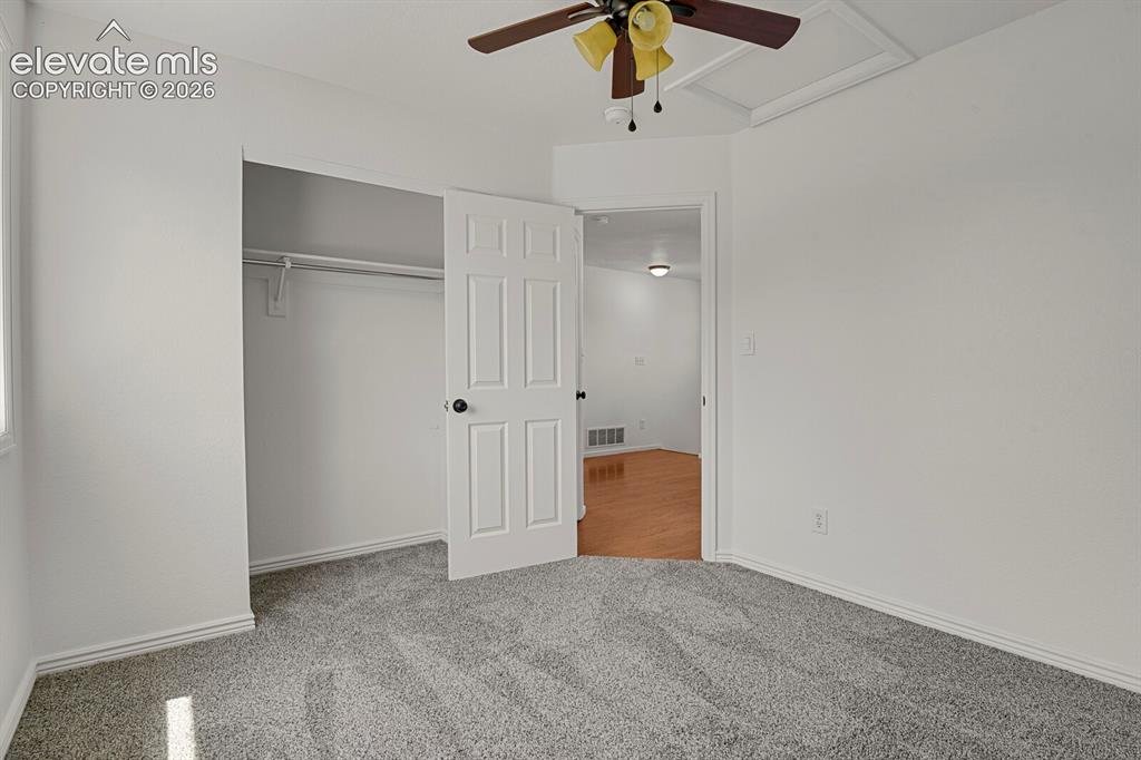 Image 35 of 49: Bedroom with grey textured carpet flooring and white baseboards