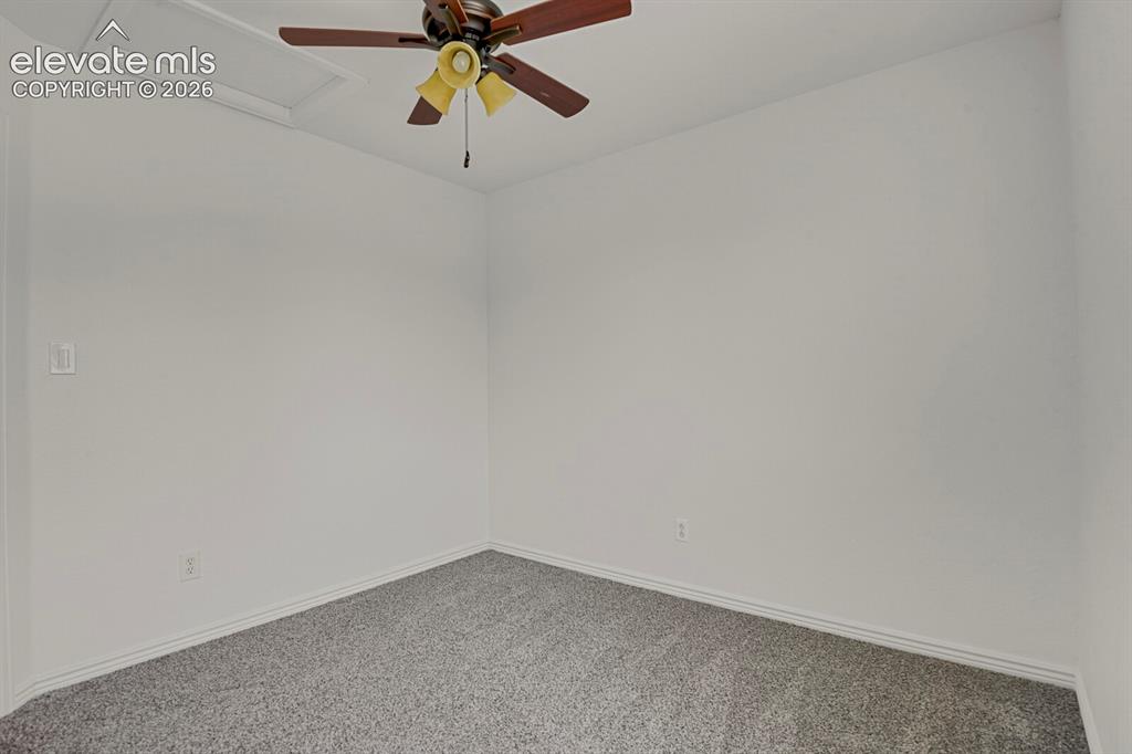Image 36 of 49: Neutral white wall finishes, neutral grey carpet, baseboard trim, and a cei
