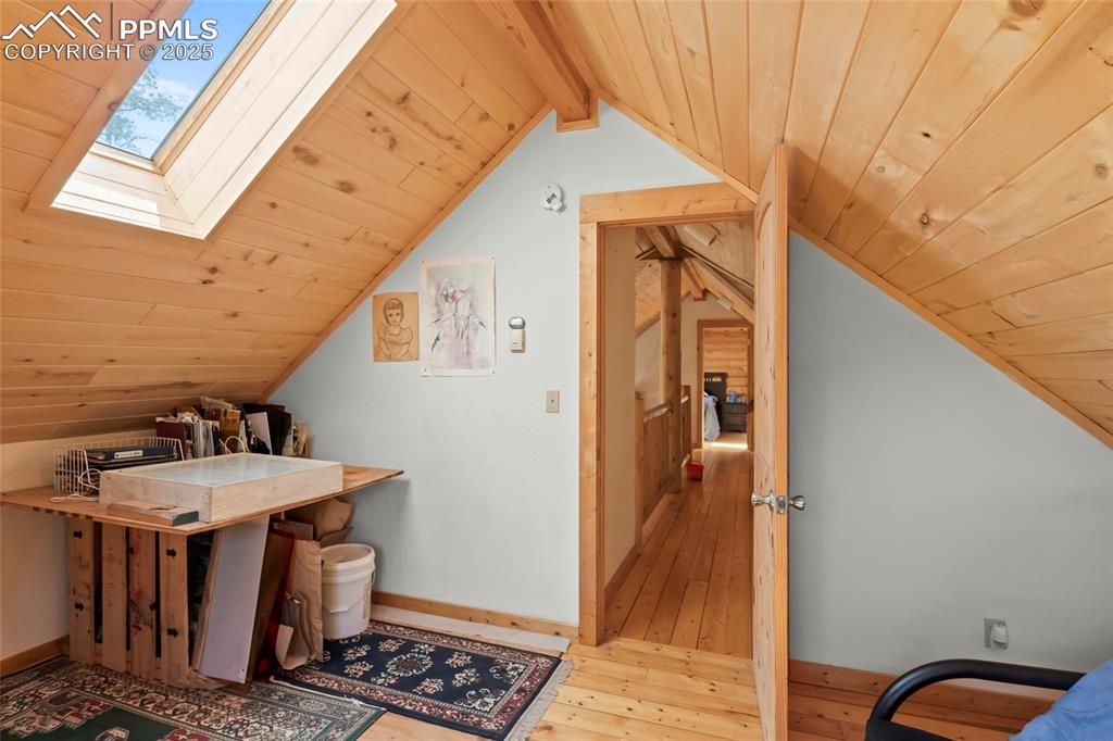 Image 14 of 33: Office with wooden ceiling, light wood-type flooring, and a skylight