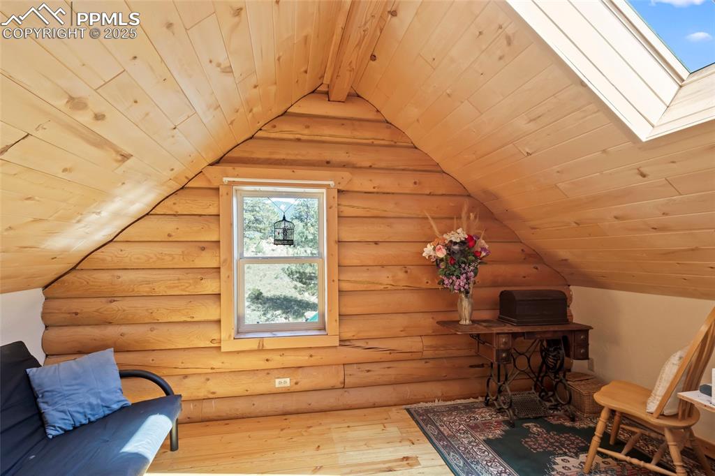 Image 15 of 33: Bonus room featuring wood ceiling, wood-type flooring, a skylight, lofted c