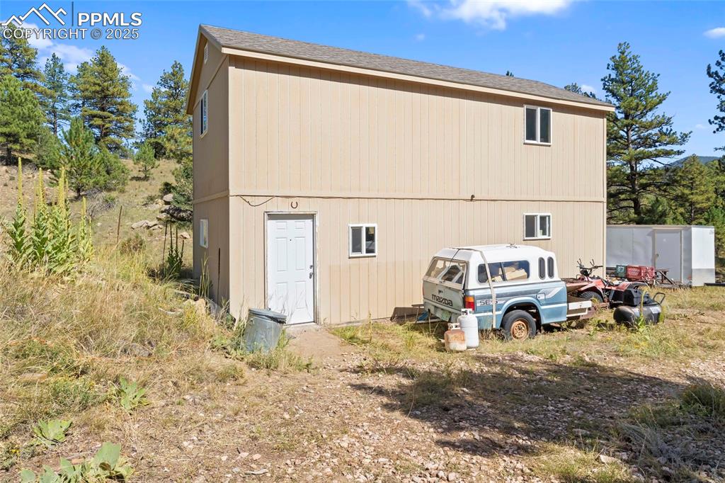 Image 20 of 33: Back of property featuring an outbuilding and roof with shingles
