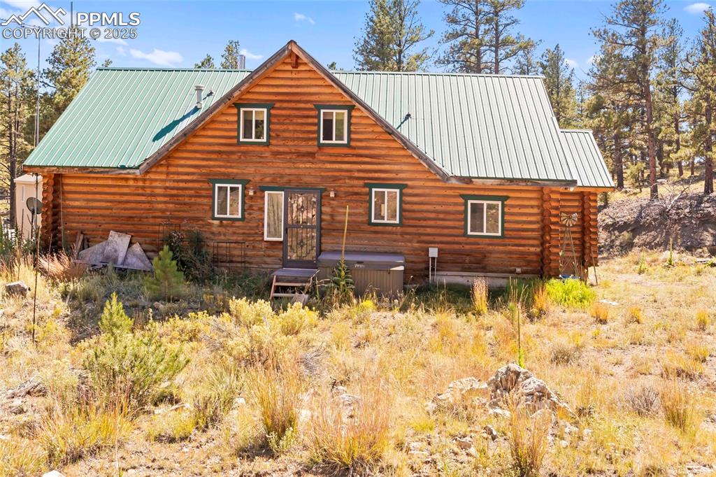 Image 22 of 33: Back of property featuring log siding and a metal roof