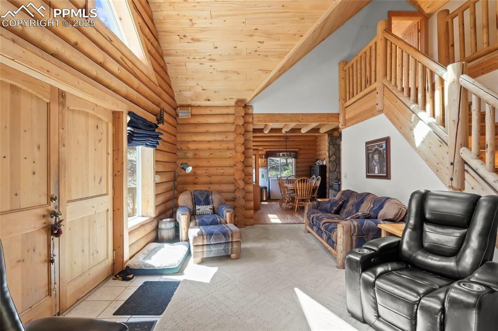 Image 3 of 33: Living area featuring plenty of natural light, wood ceiling, high vaulted c