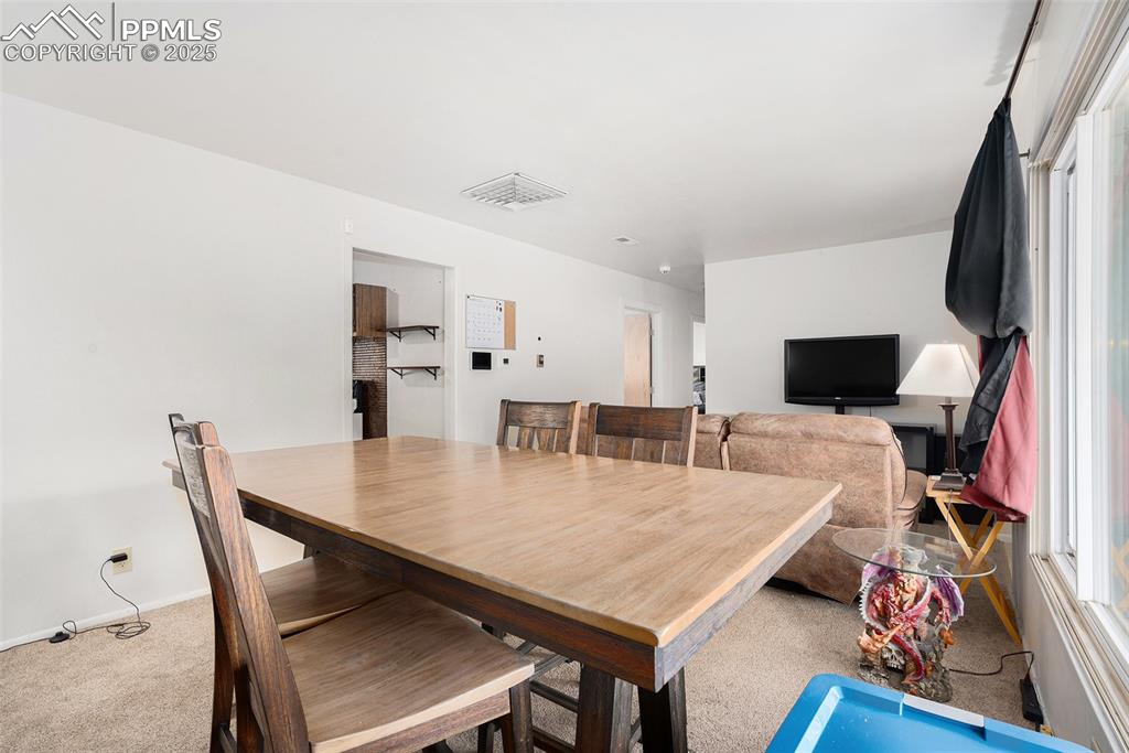 Image 10 of 30: Carpeted dining space with healthy amount of natural light