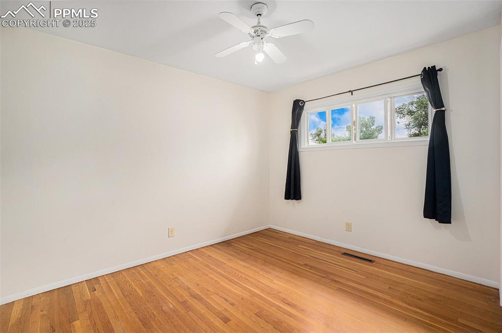 Image 20 of 30: Spare room with light wood-type flooring and ceiling fan