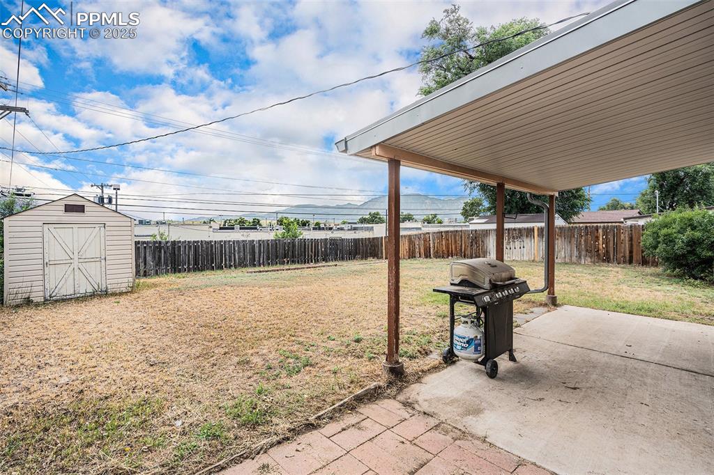 Image 23 of 30: Fenced backyard featuring a patio and a storage shed