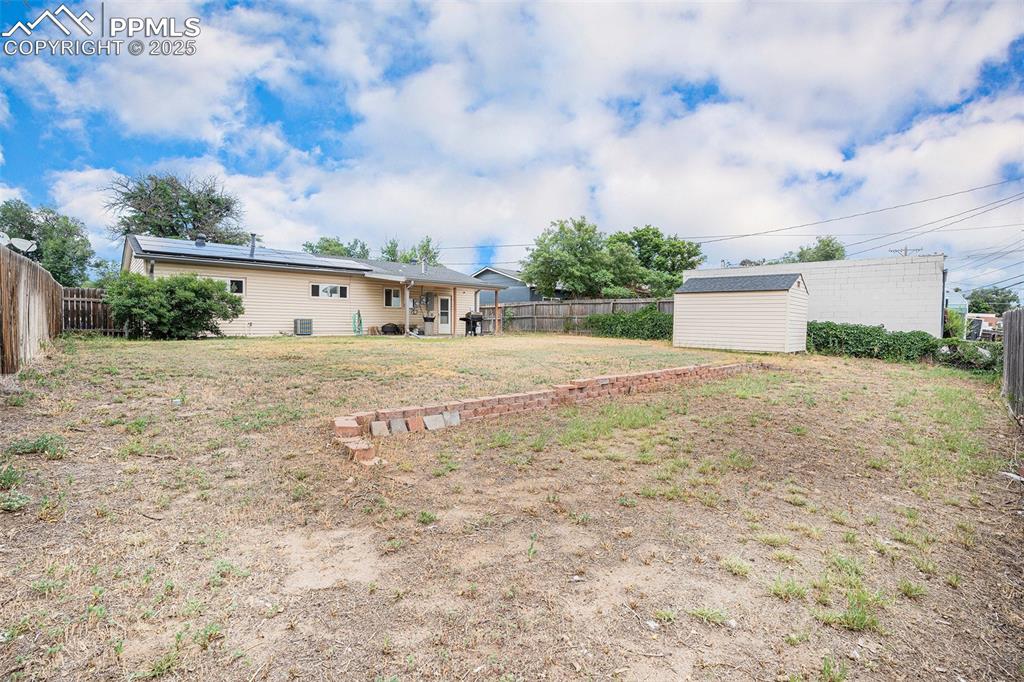 Image 29 of 30: Fenced backyard featuring a storage shed