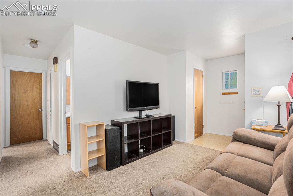 Image 5 of 30: Living area featuring light carpet