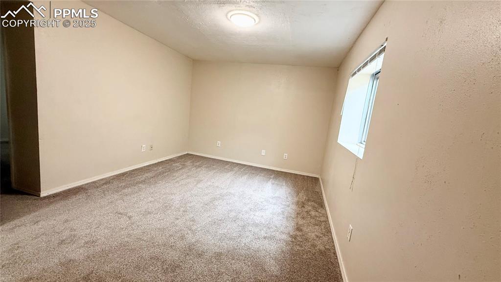 Image 10 of 16: Unfurnished room with carpet and baseboards