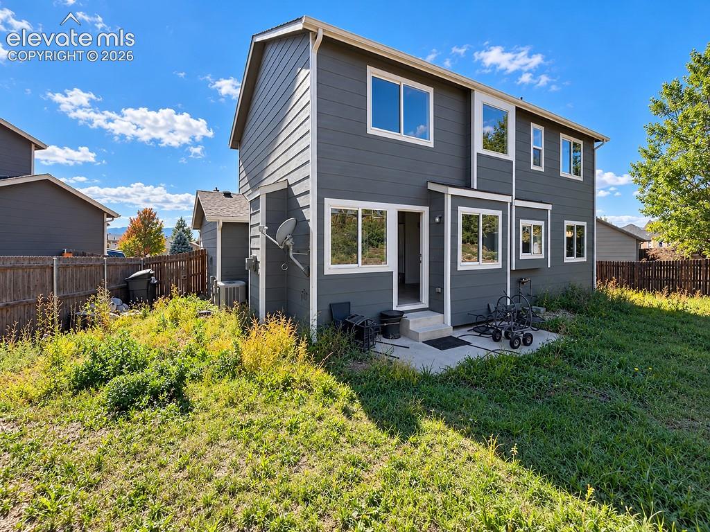 Image 28 of 32: Two-story exterior featuring grey lap siding, crisp white trim, multiple du