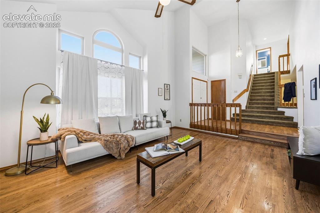 Image 10 of 49: Vaulted ceilings with large arched windows, wood-finish flooring, and woode