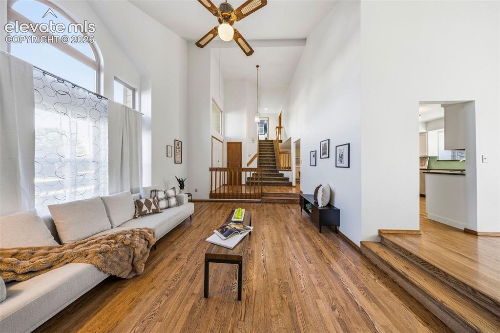 Image 11 of 49: Vaulted ceilings, expansive arched windows, wood-finish flooring, and multi