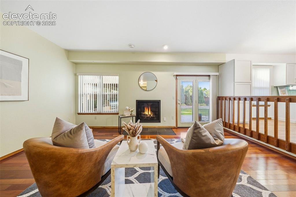 Image 21 of 49: Living area featuring wood-finish flooring, a built-in fireplace with a sto