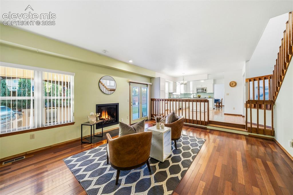 Image 22 of 49: Living area featuring wood-finish flooring, a recessed fireplace, glass-pan