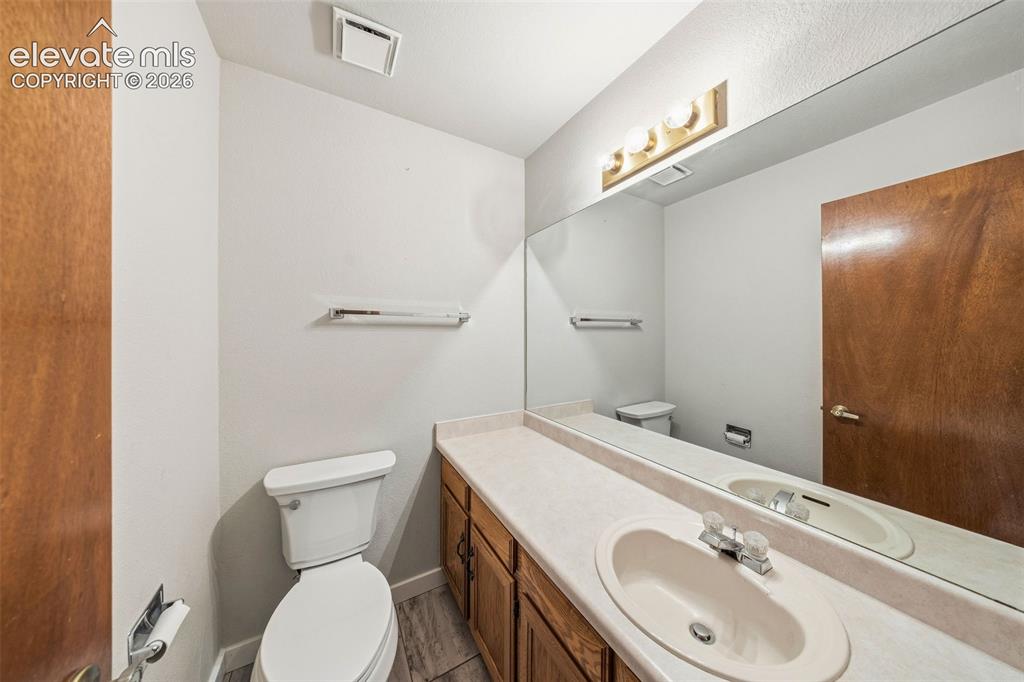 Image 24 of 49: Bathroom featuring a single-sink vanity with wood-finish cabinetry, an inte