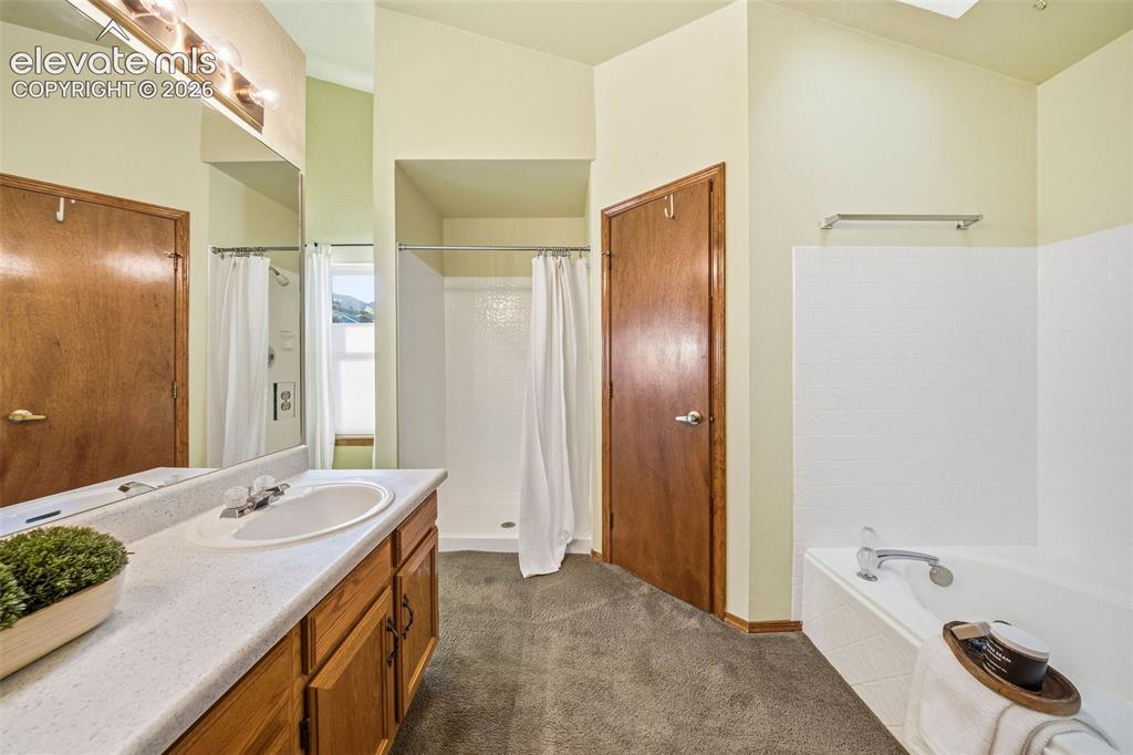 Image 31 of 49: Bathroom featuring a vanity with a solid-surface countertop, an integrated