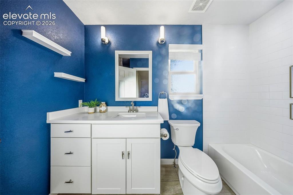 Image 32 of 49: White vanity with countertop basin, wall-mounted light fixtures, built-in f