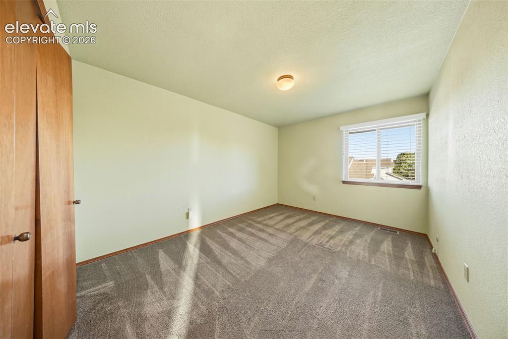 Image 35 of 49: Room featuring textured carpeting, neutral wall coloring, flush-mount ceili