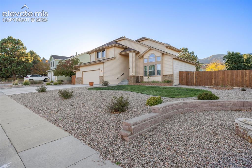 Image 4 of 49: Exterior featuring light-colored horizontal siding, stone masonry accents,