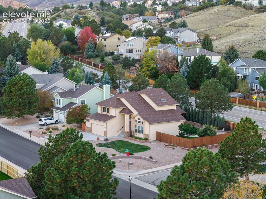 Image 45 of 49: Two-story residence featuring shingled roofing, an attached garage, xerisca