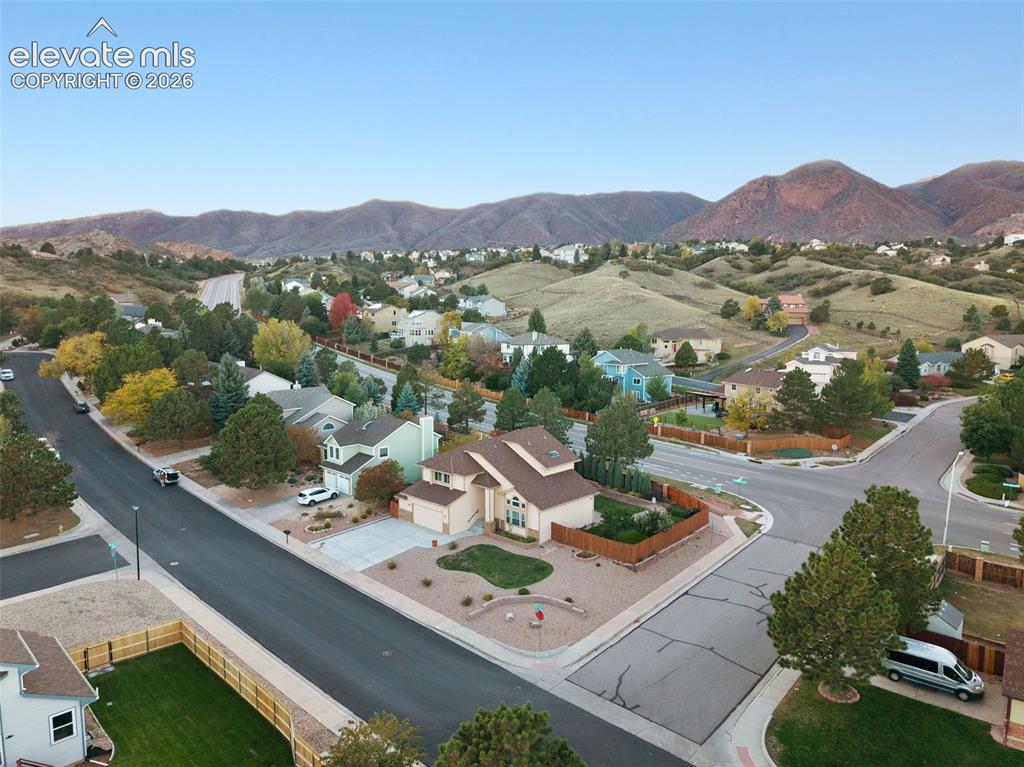 Image 48 of 49: Corner lot residence featuring a multi-level exterior, concrete driveway, s