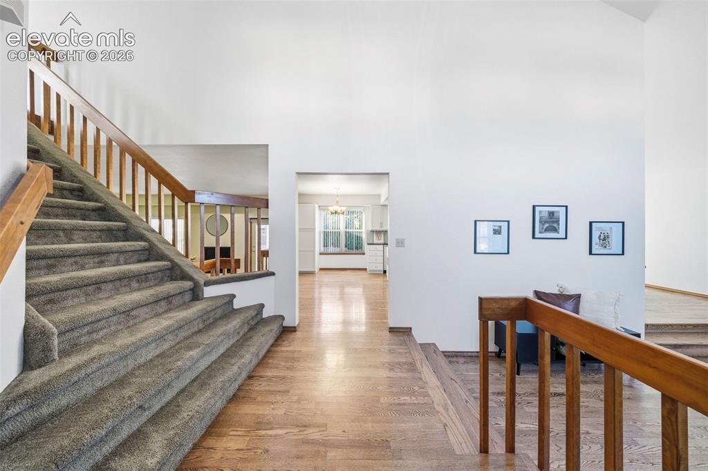 Image 5 of 49: Foyer featuring vaulted ceilings, wood-finish flooring, and a carpeted stai