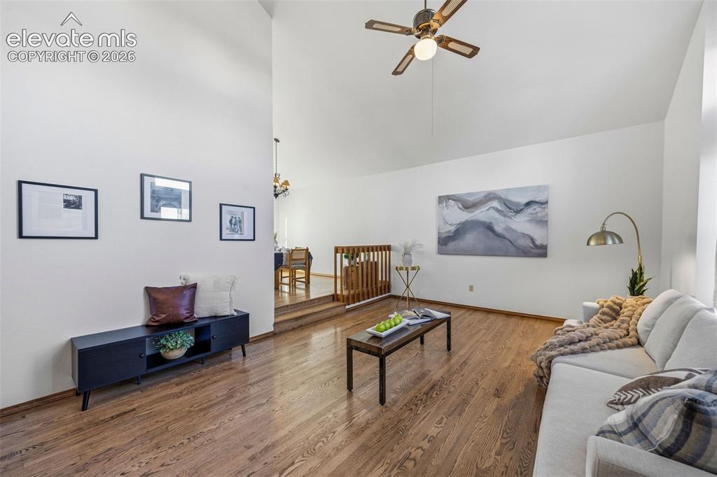 Image 6 of 49: Living area featuring vaulted ceilings, wood-finish flooring, and a ceiling