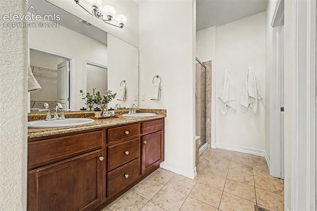 Image 13 of 44: Primary bedroom features vaulted ceiling and windows overlookiing the back